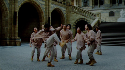 a group of men dancing in front of a building