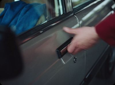 a person's hand on a door handle of a car