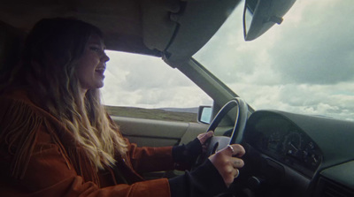 a woman driving a car on a cloudy day