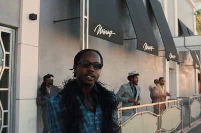 a man wearing sunglasses standing in front of a building