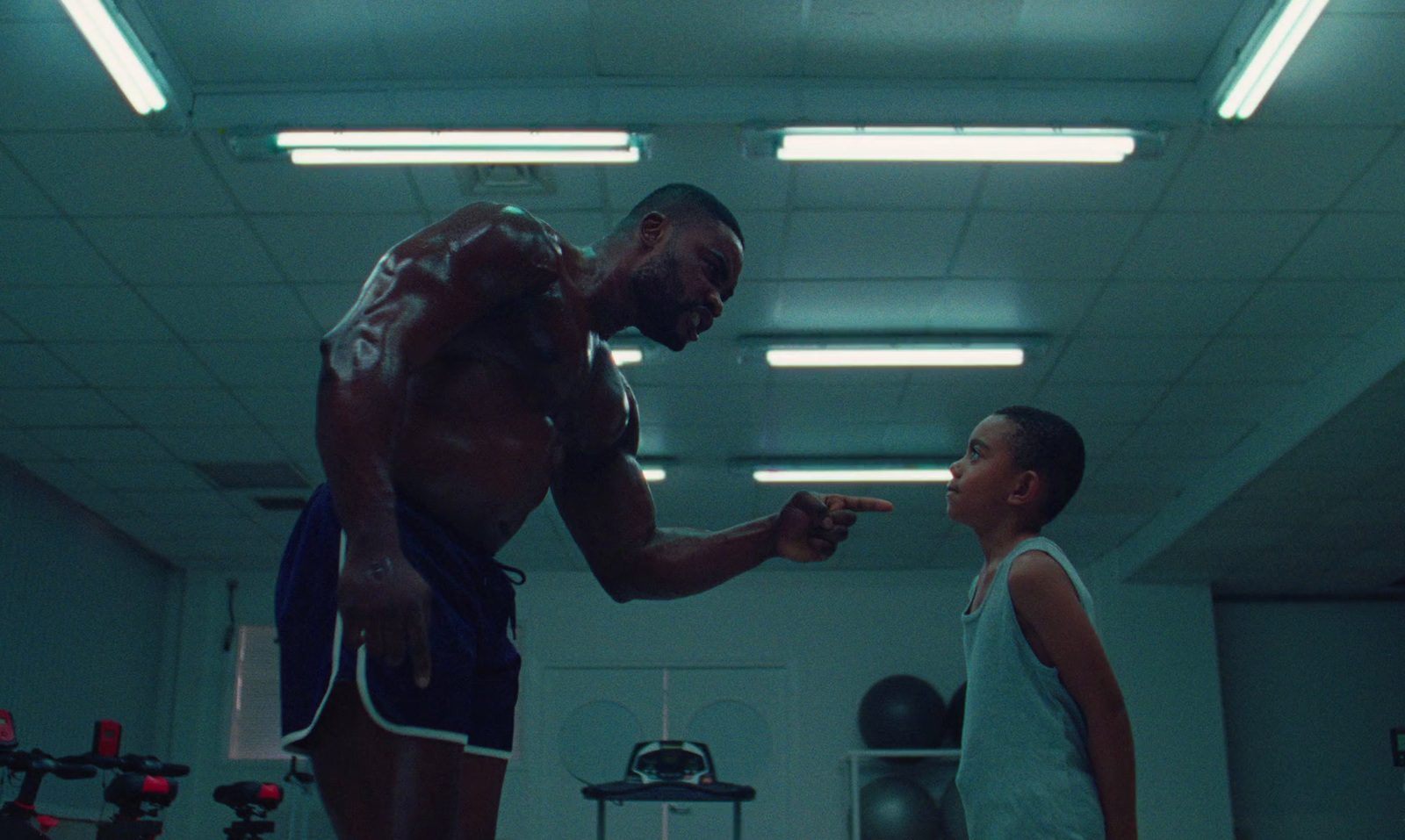 a man standing next to a woman in a gym