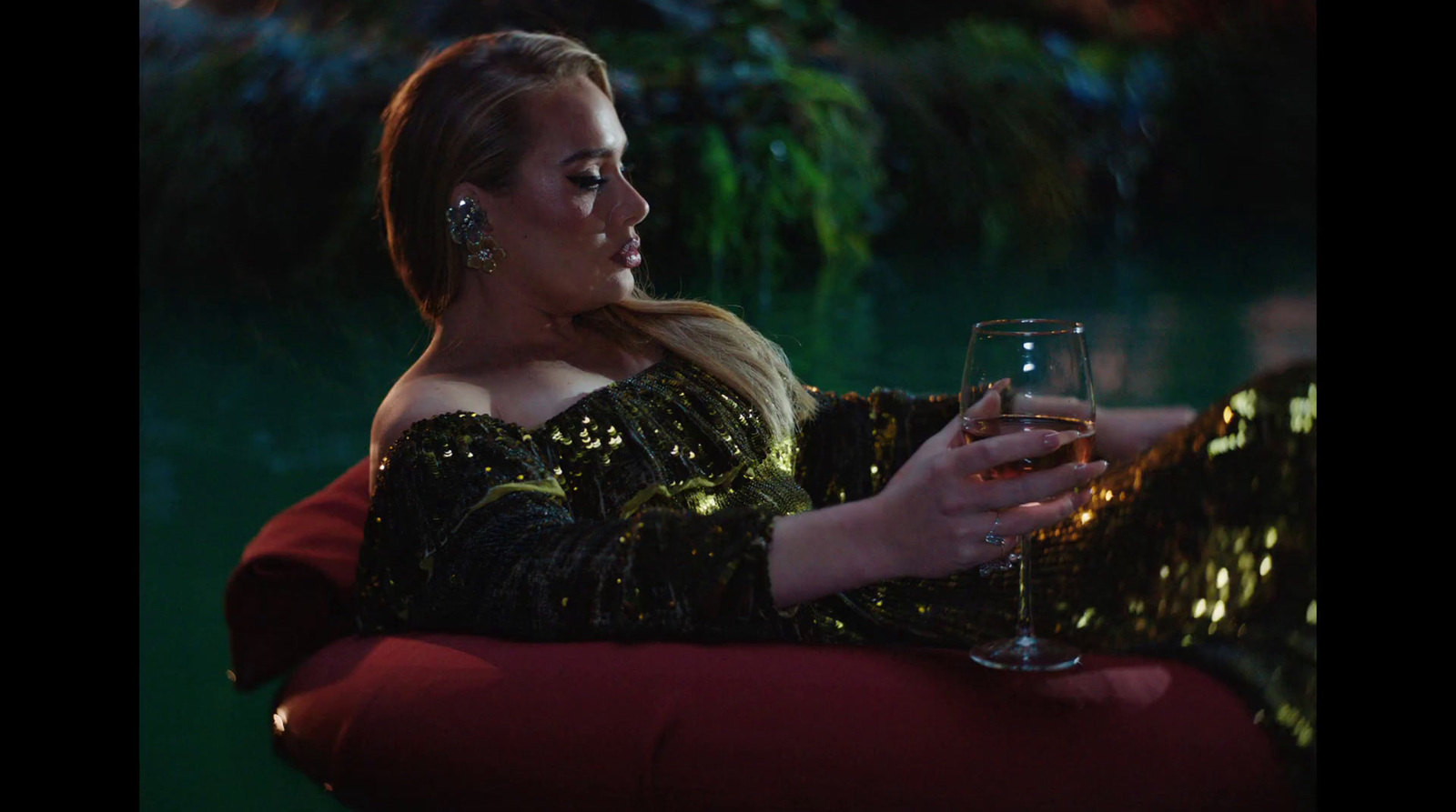 a woman sitting on a chair holding a glass of wine