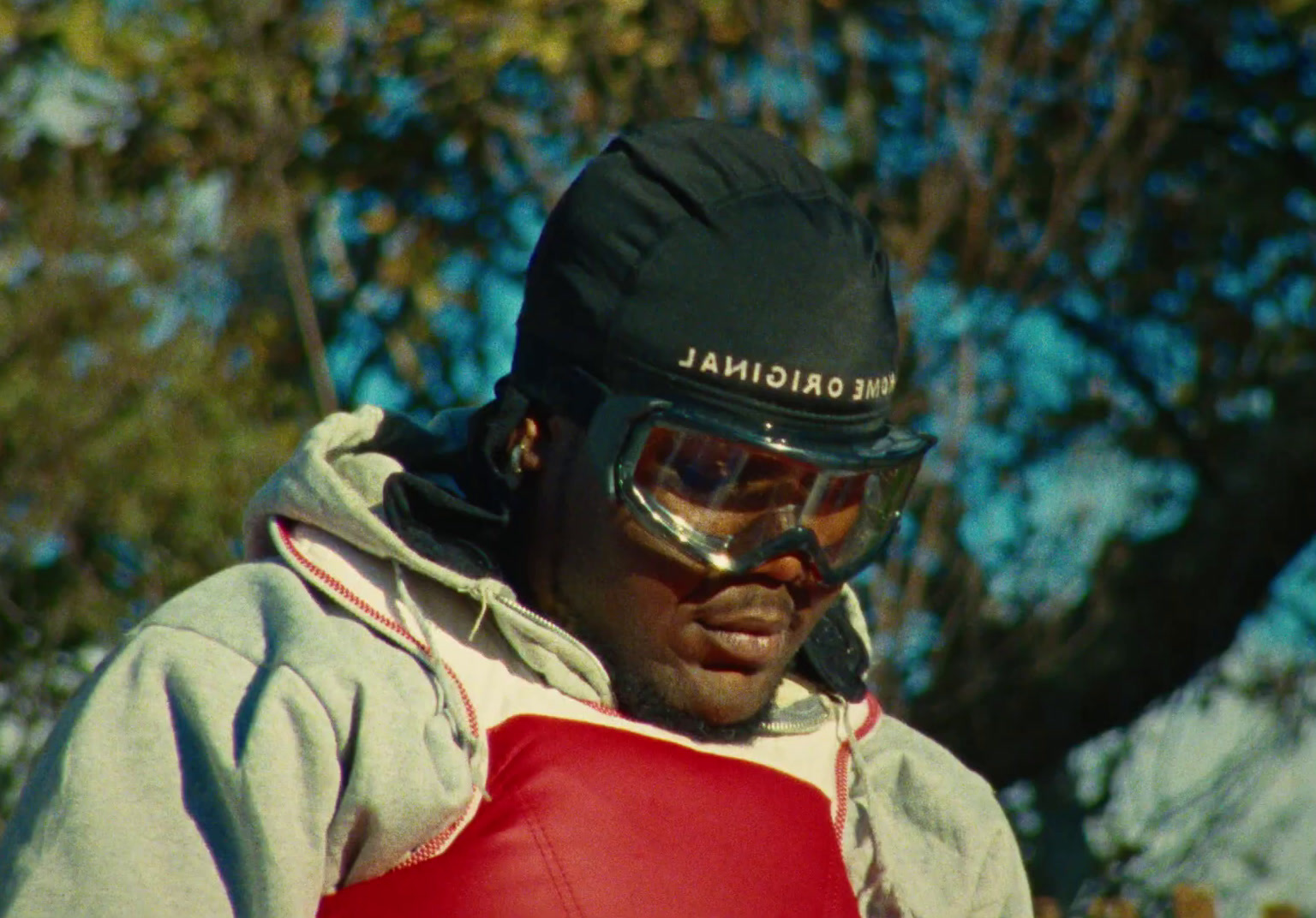 a man wearing a helmet and goggles with trees in the background