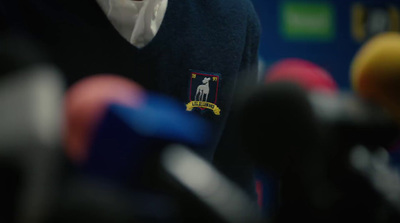 a close up of a person wearing a sweater and tie