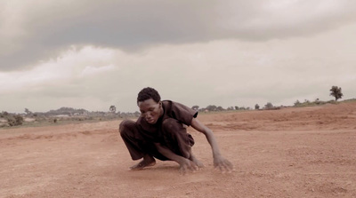 a man crouching down to pick up a frisbee