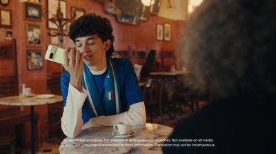 a woman sitting at a table talking on a cell phone