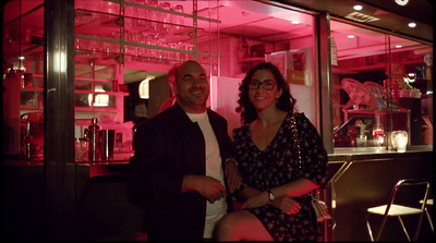 a man and a woman standing in front of a bar