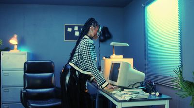 a woman standing at a desk with a computer