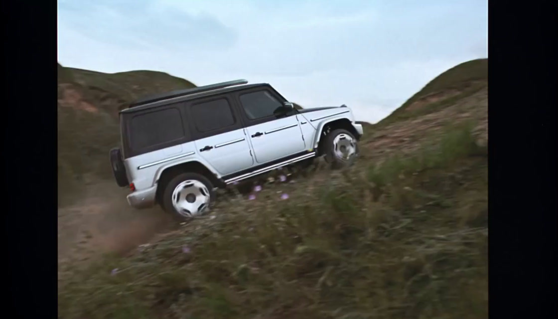 a white suv driving down a dirt road