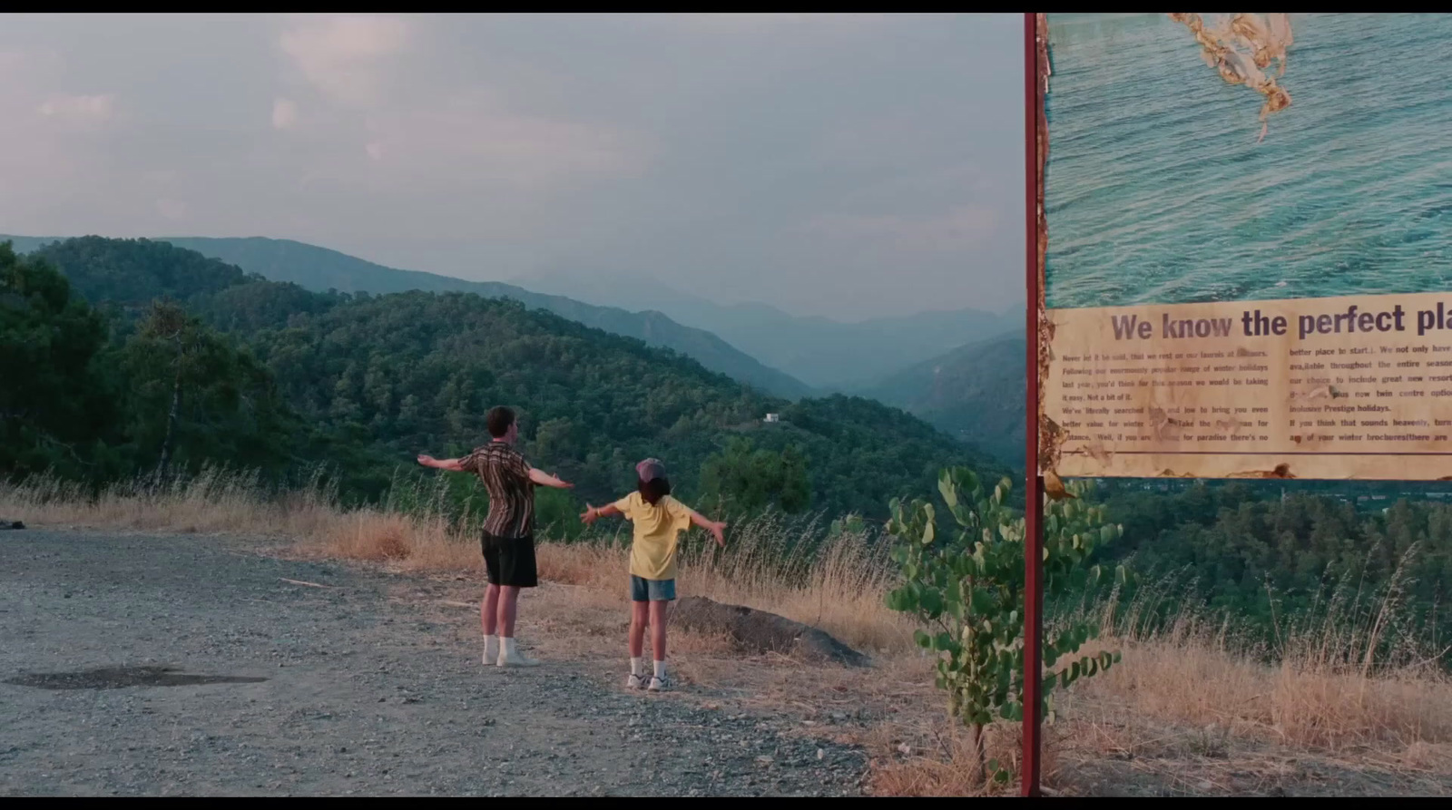 a couple of people standing on a dirt road