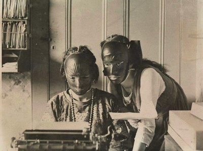 a man and a woman are looking at a typewriter