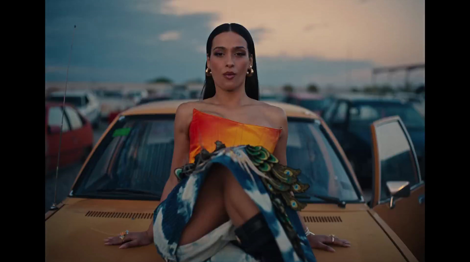 a woman sitting on the hood of a car