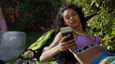 a woman sitting on a motorcycle looking at a cell phone