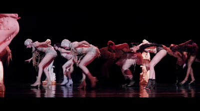 a group of dancers on a stage with a black background