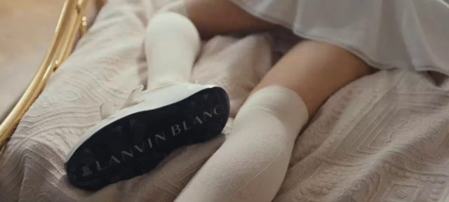 a person laying on a bed with a pair of white socks