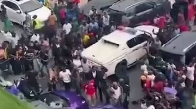 a group of people standing around a white car