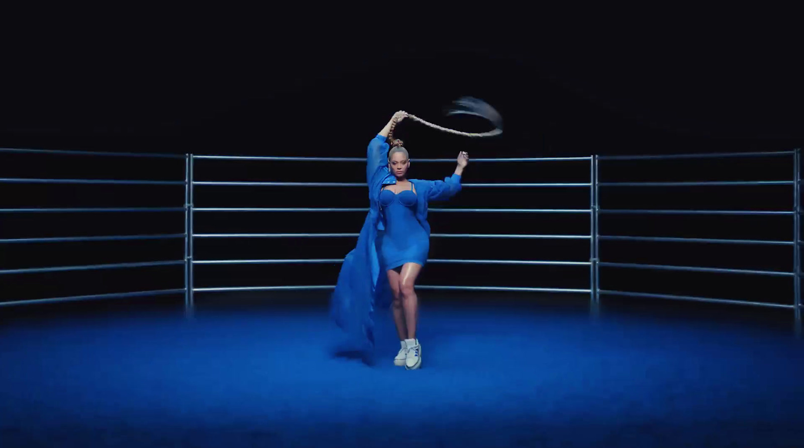 a woman in a blue dress holding a frisbee