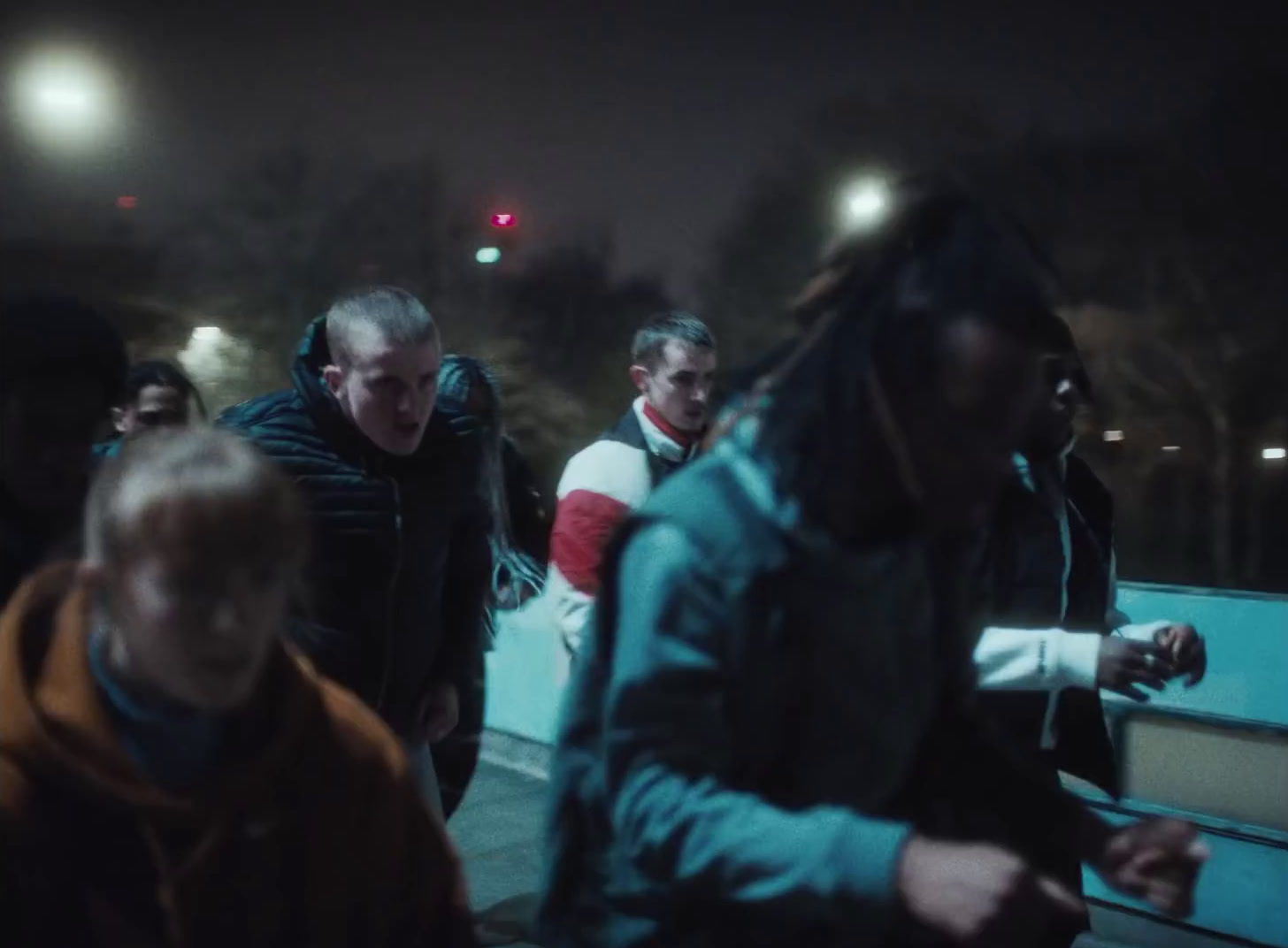 a group of people walking down a street at night