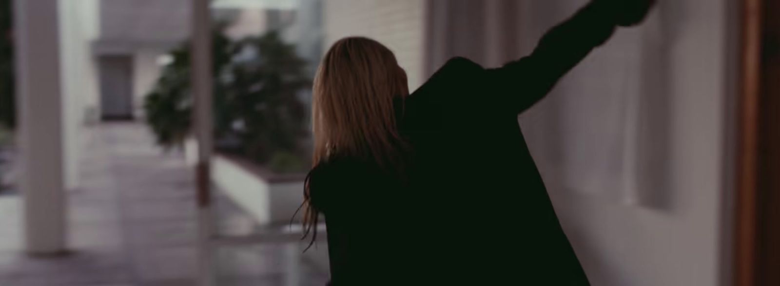 a woman standing in front of a window with her arm in the air