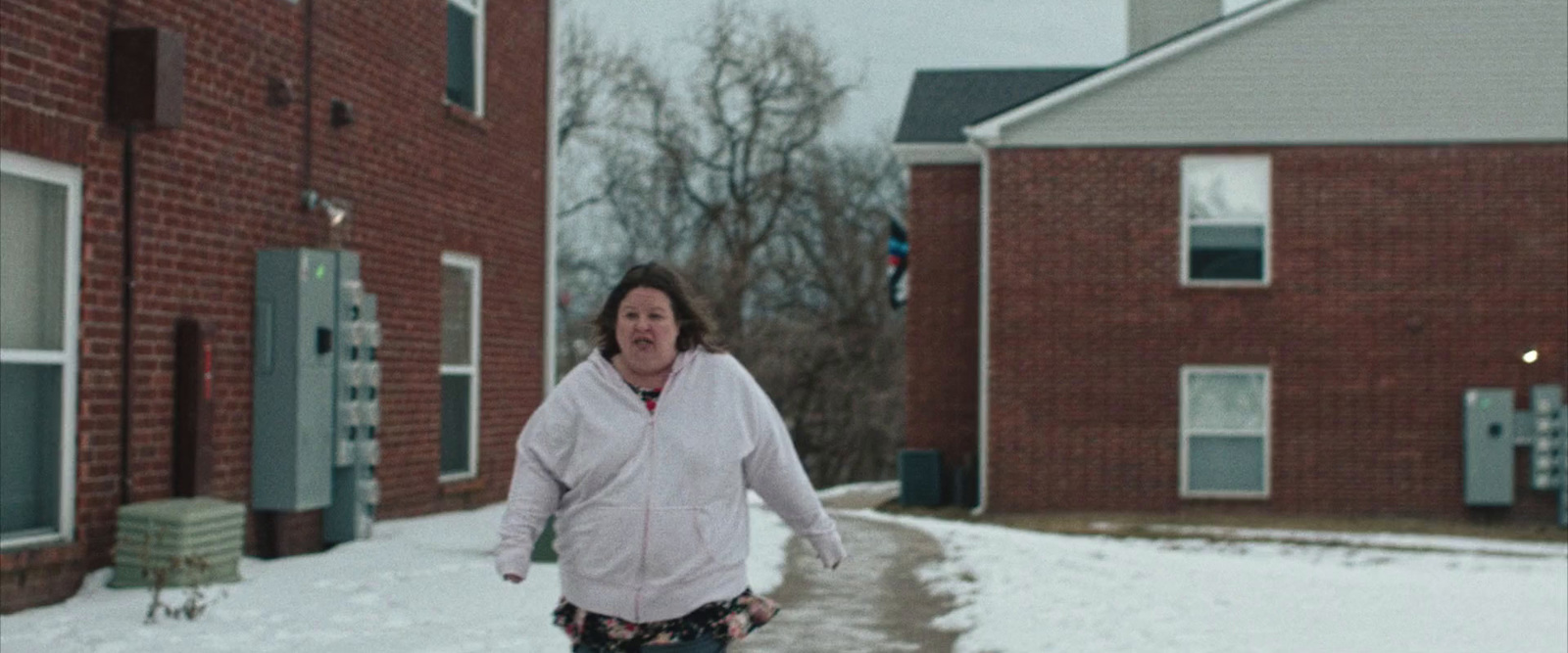 a woman walking down a snow covered street