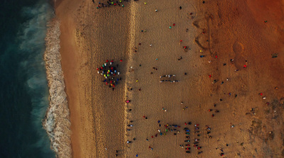 a group of people standing on top of a sandy beach