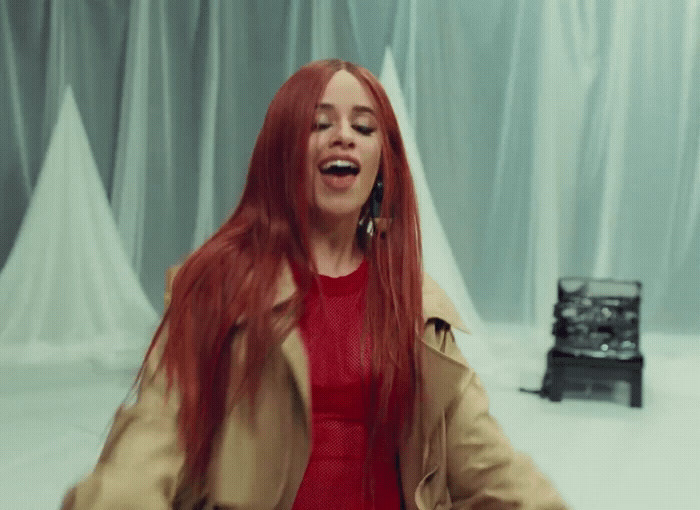 a woman with long red hair is laughing