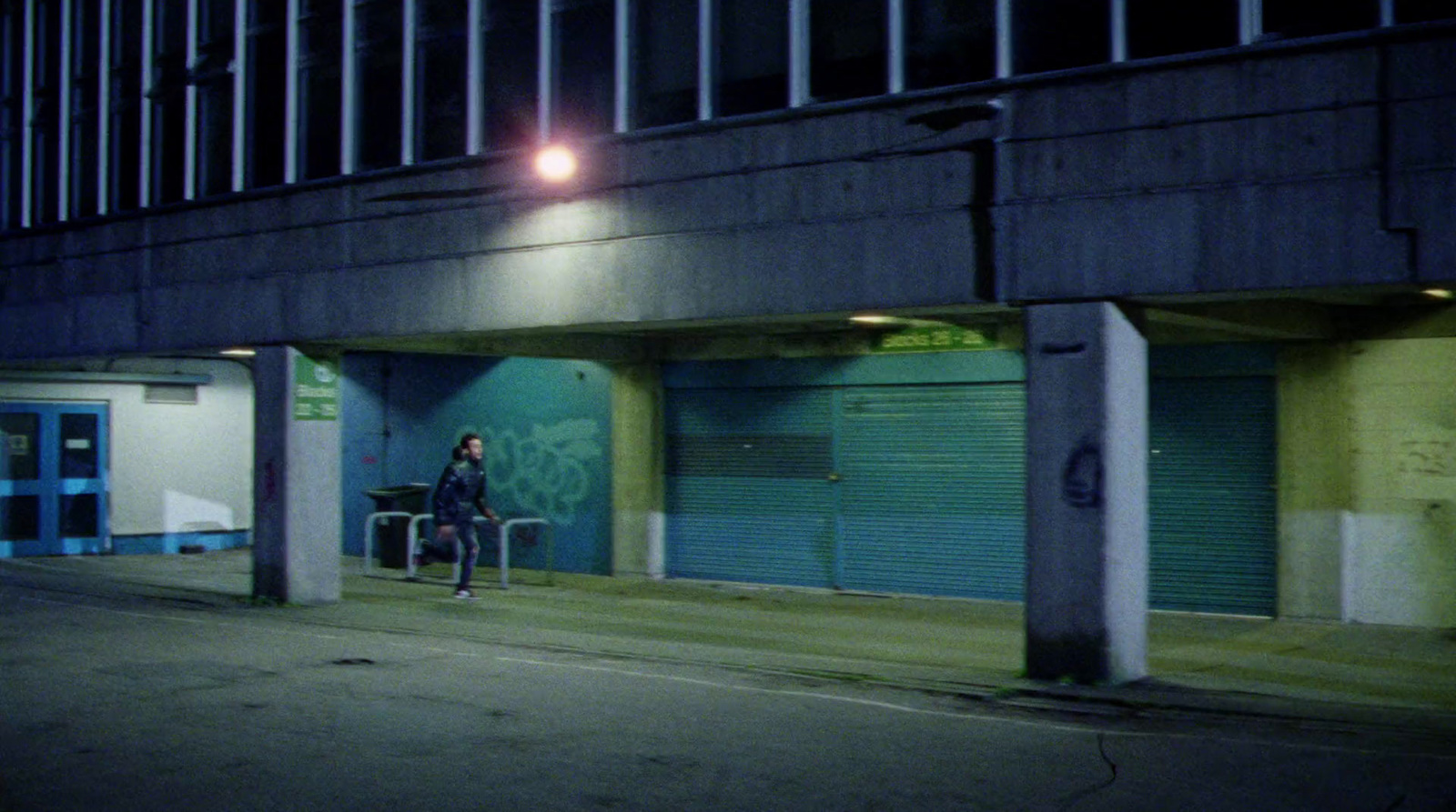 a person riding a skateboard down a street at night