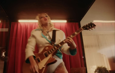 a woman is playing a guitar in a room