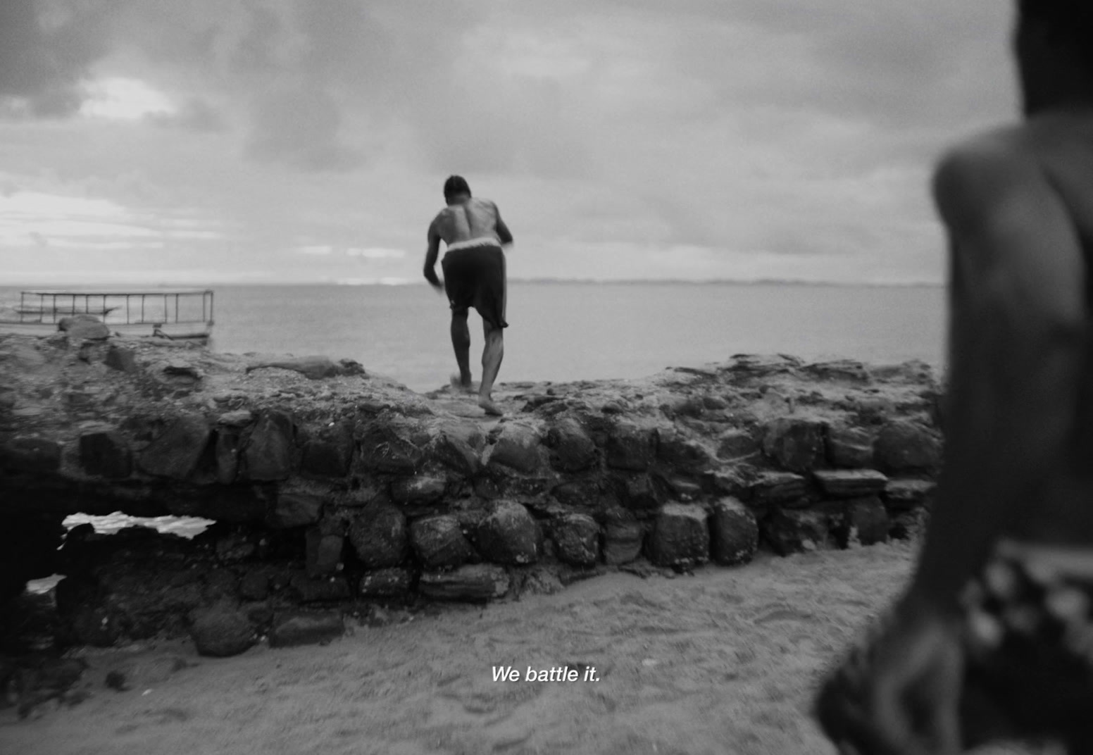 a man standing on top of a beach next to the ocean