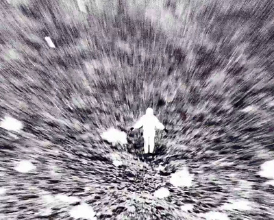 a black and white photo of a person standing in the middle of a field