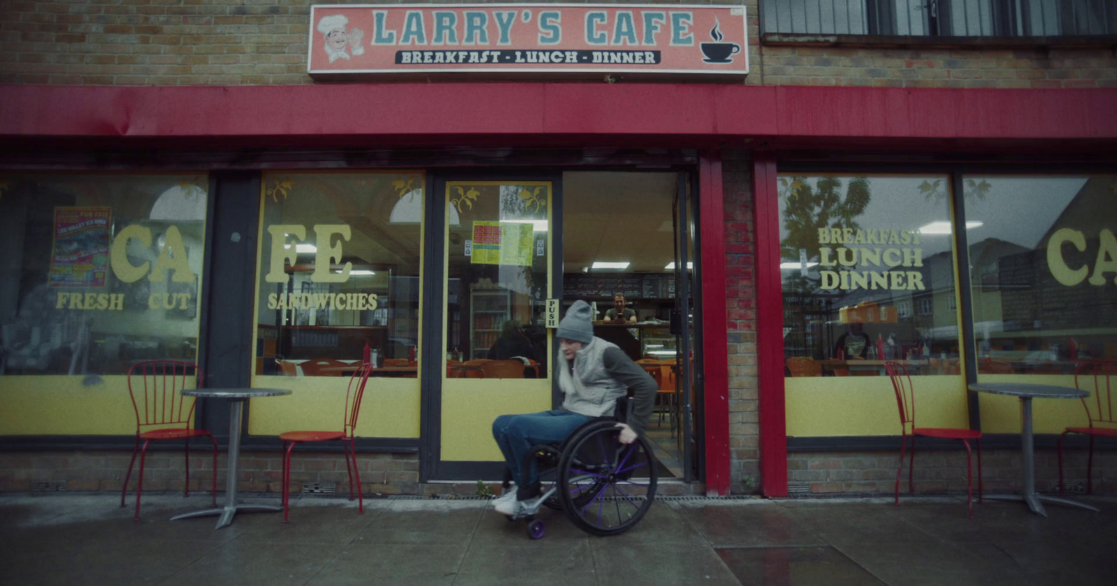 a person sitting in a wheel chair in front of a restaurant