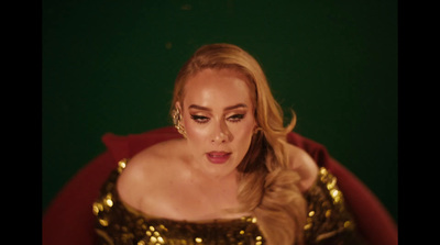 a woman in a gold dress sitting on a red chair