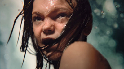 a woman with wet hair and water on her face