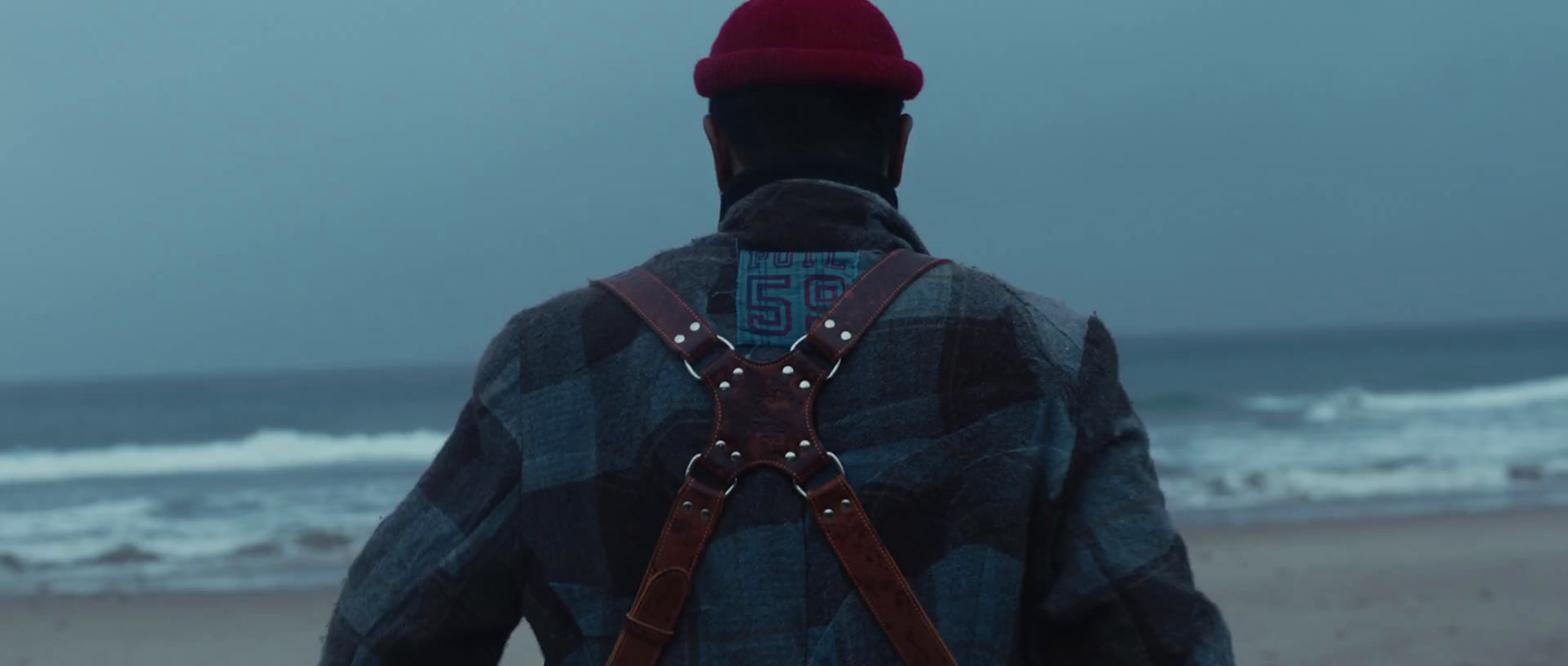 a person wearing a backpack and a hat on a beach