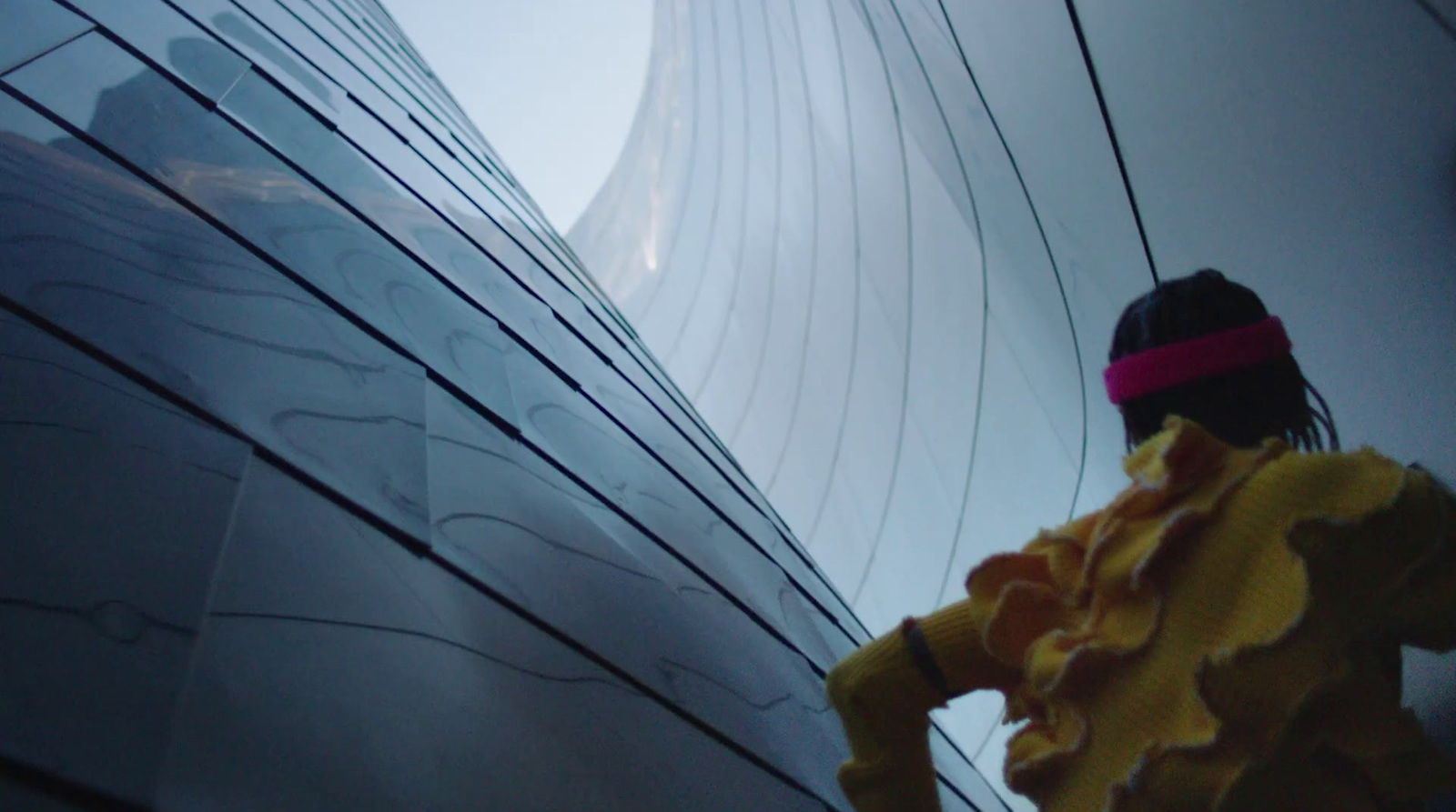 a woman standing in front of a tall building