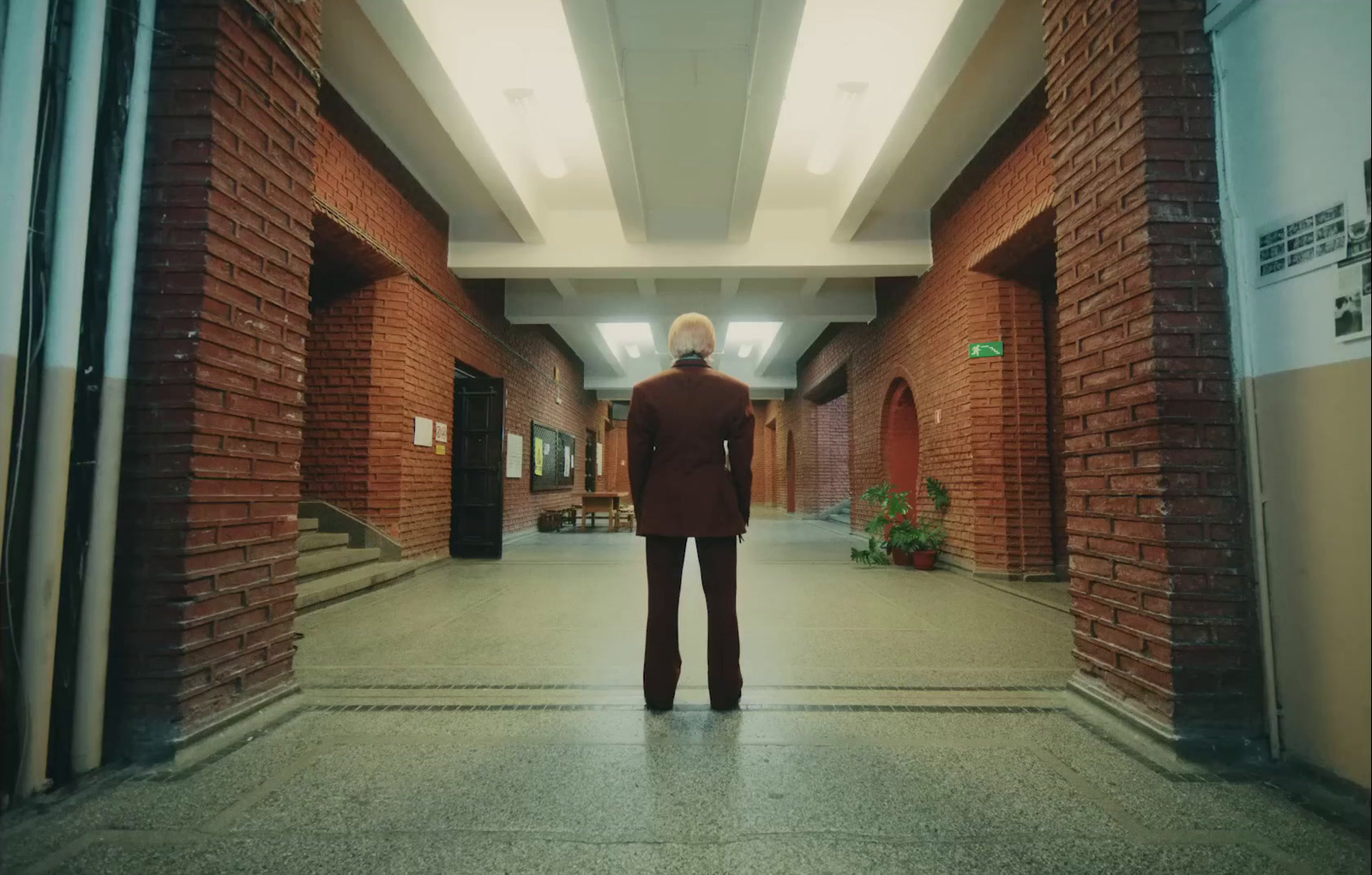 a man in a suit standing in a hallway