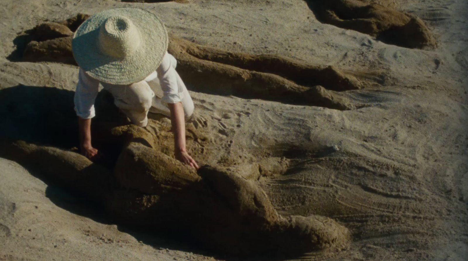 a little boy playing in the sand at the beach