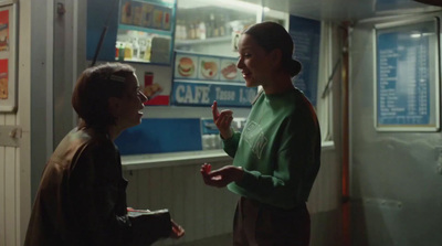 two women standing in a room talking to each other