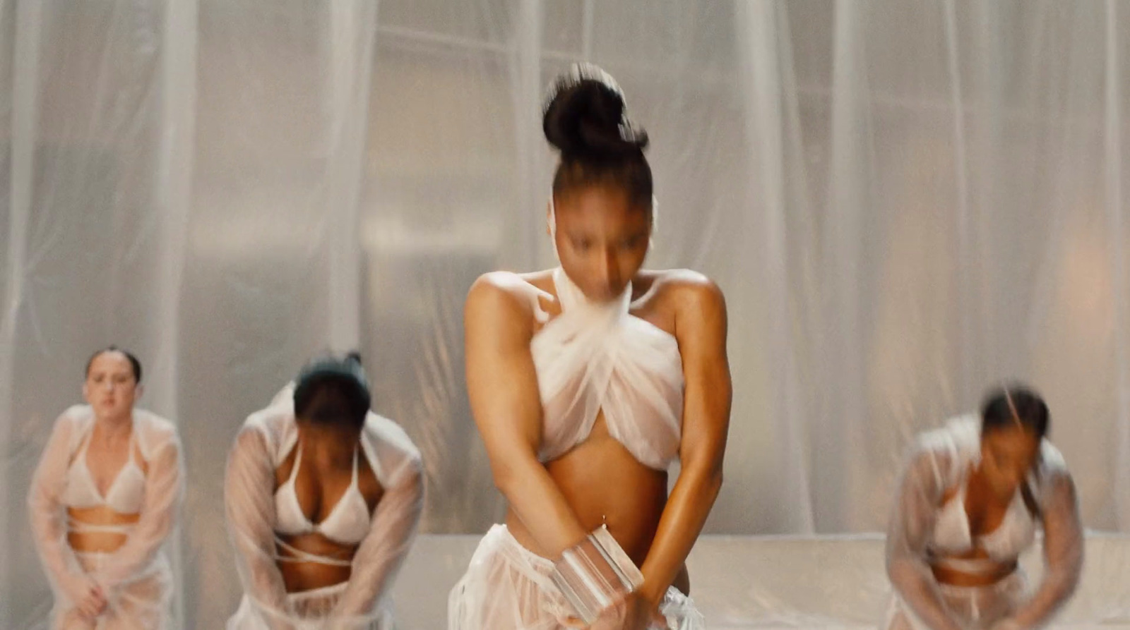 a group of women in white lingerie in front of a curtain