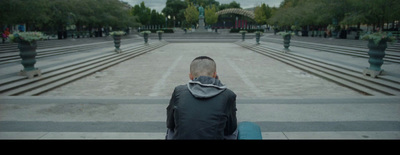 a man sitting on a bench in a park