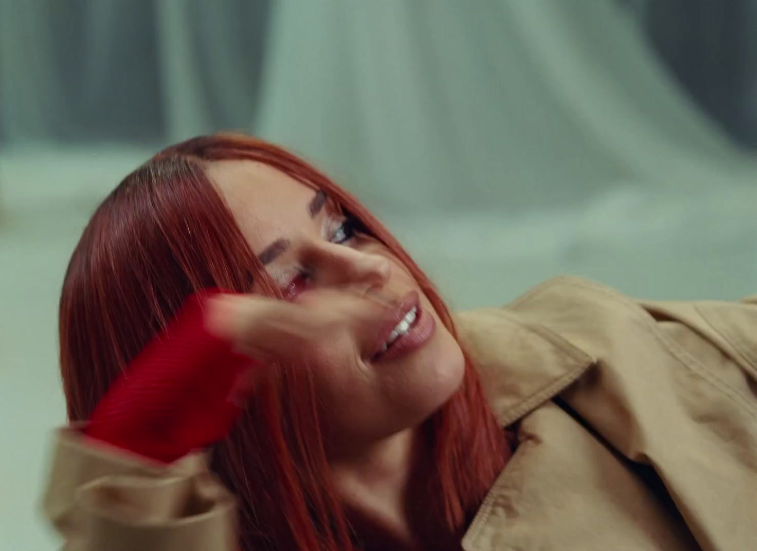 a woman with red hair is smiling and holding a toothbrush