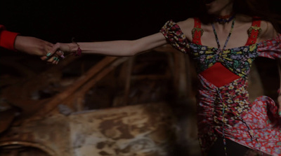 a woman in a colorful dress holding a red purse