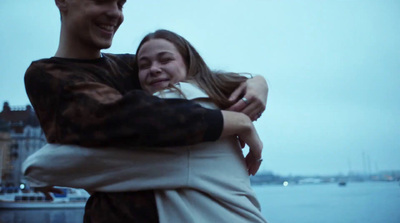 a man and a woman hugging each other by the water