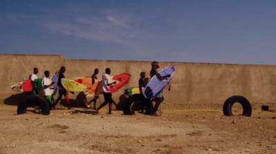 a group of people holding surfboards in front of a wall