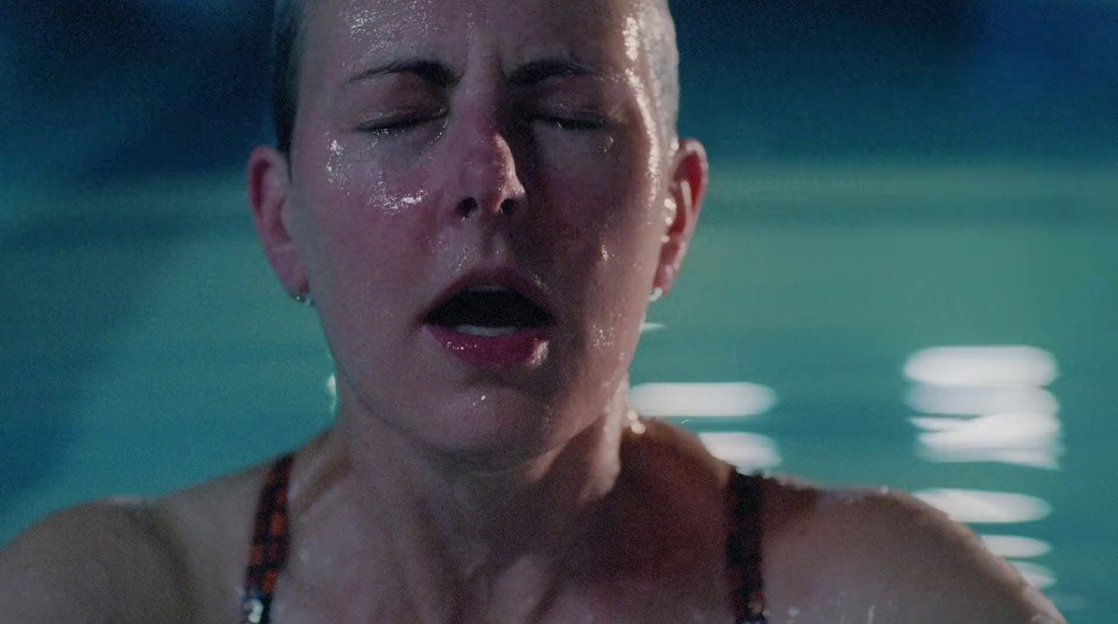 a woman with her eyes closed in a swimming pool