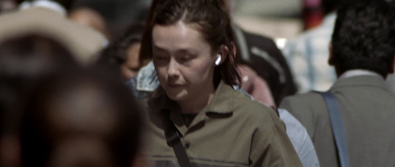 a woman wearing a brown shirt and ear phones