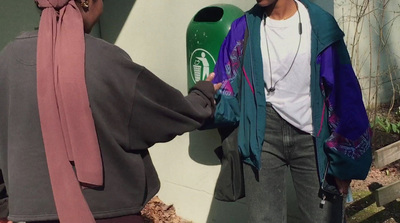 a man standing next to a woman near a wall