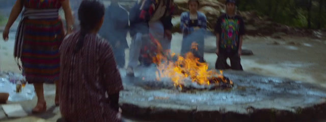 a group of people standing around a fire pit