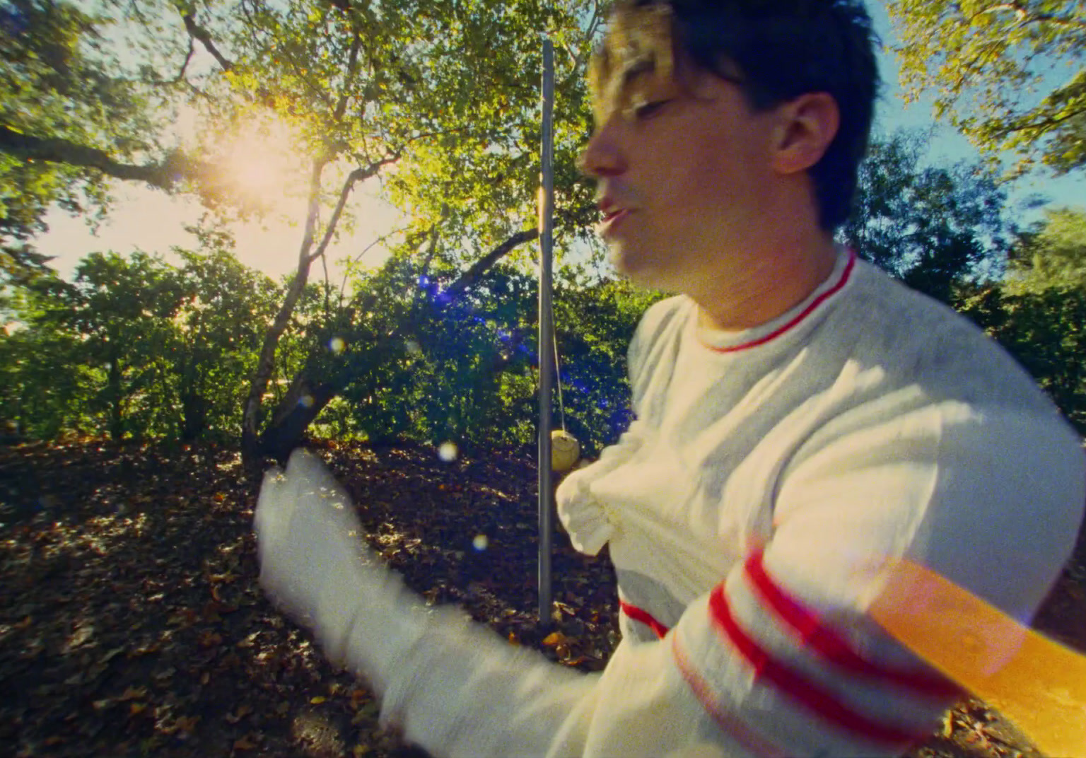 a man holding an umbrella in a wooded area