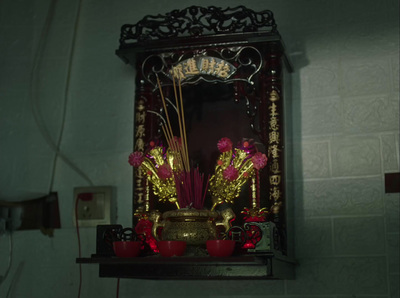 a small shrine with flowers and candles on a shelf